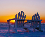 a chair on the beach at sunset